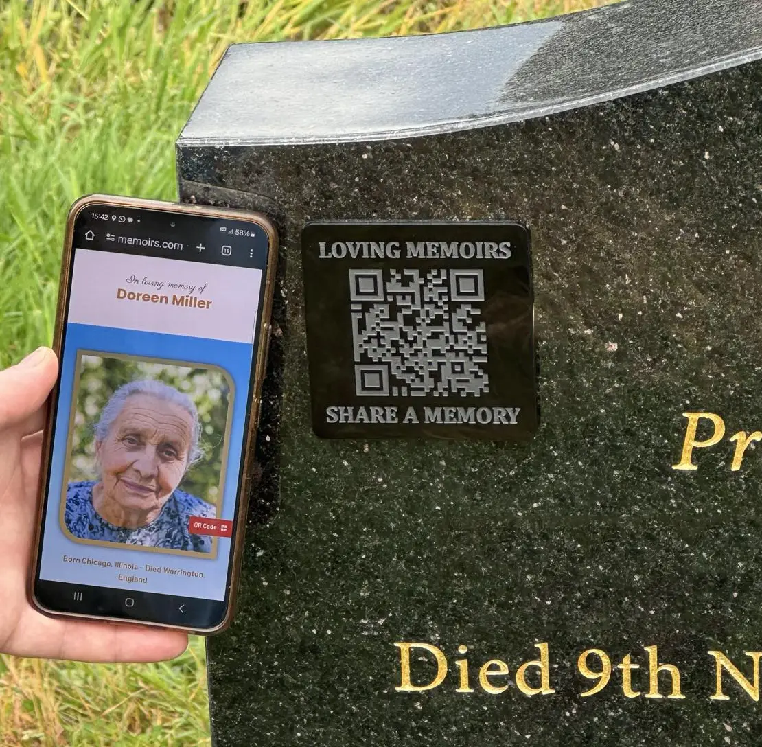 An engraved QR plaque supplied through a funeral director partnership, fixed to a memorial stone